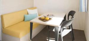 a room with a table and a yellow couch at ZEcamping 3 étoiles familial pet friendly avec piscine et restaurant in Sandrans