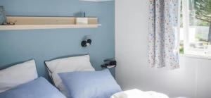 a room with a bed with blue walls and a window at ZEcamping 3 étoiles familial pet friendly avec piscine et restaurant in Sandrans