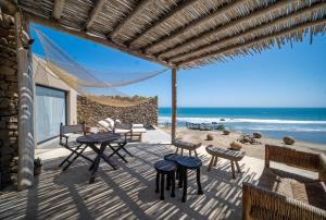 a patio with tables and chairs and the beach at Inkaterra Cabo Blanco in Talara