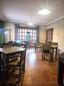 a person standing in a dining room with tables and chairs at Casa Rural Mirabueno in Cuenca