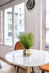 a white table with a potted plant on it at Escapade à deux à 10mn de Paris in Gentilly