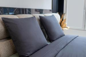 a couch with two black pillows on it at Escapade à deux à 10mn de Paris in Gentilly