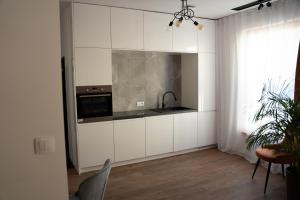 a kitchen with white cabinets and a sink at Sauna Cafee & Beds in Český Těšín