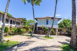 a view of the hotel from the beach with palm trees at Pousada Canto dos Encantos in Barra Grande