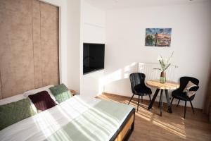 a bedroom with a bed and a table and chairs at Sauna Cafee & Beds in Český Těšín