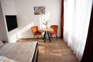a room with a table and two chairs and a tv at Sauna Cafee & Beds in Český Těšín +11 photos