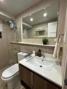 a bathroom with a sink and a toilet and a mirror at 1413 Home Suites Arezzo Place Davao in Davao City +12 photos