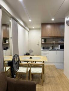 a kitchen with a table with chairs and a fan at 1413 Home Suites Arezzo Place Davao in Davao City