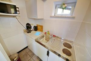 a small kitchen with a sink and a window at Pension Haus Sonneck in Wildemann +38 photos