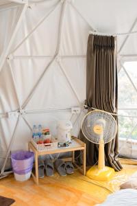 a room with a tent with a fan and a table at ลักษณ์ภูชี้ฟ้า 2 แบบโดม in Ban Seng Choi