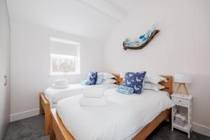 two twin beds in a room with white walls at Charlotte Cottage - Minutes from Poole Park, with Feature Log Burner in Poole