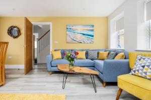 a living room with a blue couch and a table at Charlotte Cottage - Minutes from Poole Park, with Feature Log Burner in Poole +30 photos