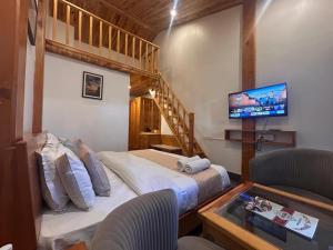 a room with two beds and a tv and a couch at The Grand Dwaper A- Luxury Rooms & Parking Walking Distance From Mall Road in Mussoorie