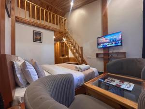a living room with two beds and a tv at The Grand Dwaper A- Luxury Rooms & Parking Walking Distance From Mall Road in Mussoorie +90 photos