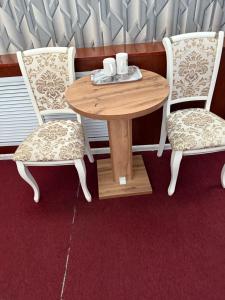 a wooden table with two chairs and a table with two cups at Zolotoi Drakon Hotel in Almaty