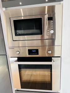 a stainless steel oven with a microwave above it at Ferienwohnung Südtor 2 in Geisingen +30 photos