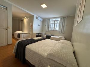 a bedroom with two beds and a window at Pousada Hospedar Imperial in Campina Grande