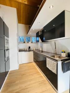 a kitchen with black and white cabinets and a wooden floor at Ferienwohnung Südtor 2 in Geisingen