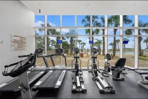 a gym with several treadmills and a large window at Gulf-Front Paradise, Steps to Beach & Pool Access in Panama City Beach