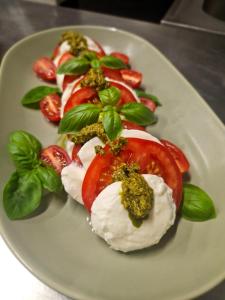 a plate of food with tomatoes and whipped cream at István Pince a penzión in Šahy