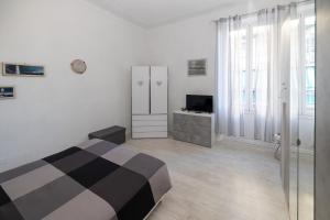 a white room with a bed and a television at Maison de Pi Sanremo in Sanremo