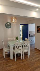 a dining room with a white table and chairs at Feel Goa at Poolview 2BHK Luxury Apartment in Arpora