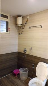 a bathroom with a toilet in a room at Feel Goa at Poolview 2BHK Luxury Apartment in Arpora +11 photos
