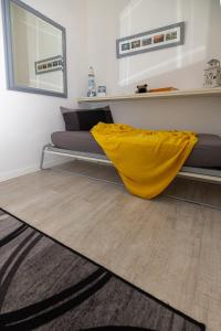 a bedroom with a bed with a yellow blanket on the floor at Maison de Pi Sanremo in Sanremo
