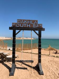 a sign on a beach with a bench and the ocean at Dakhla South Bay, WorldHotels Distinctive in Dakhla +76 photos