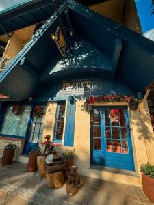 a building with a blue door and flowers on it at Petit Casa da Montanha in Gramado