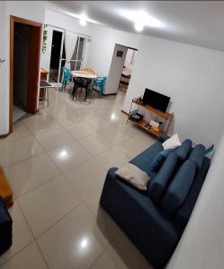 a living room with a blue couch and a table at Refúgio das montanhas - Centro in Poços de Caldas +3 photos