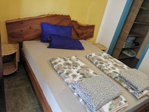 a bed with a wooden headboard and two pillows on it at palm nature lodge in Sanyang