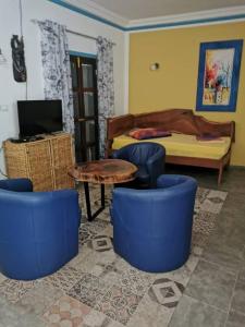 a room with blue chairs and a table and a bed at palm nature lodge in Sanyang