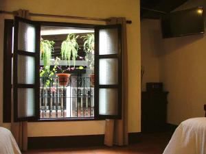 Habitación con ventana y maceta. en Hotel Villa Real Antigua, en Antigua Guatemala