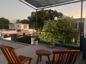 a balcony with a table and chairs on a roof at Casa Azul en Centro de Mérida in Mérida