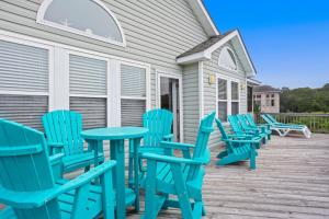 a group of blue chairs and tables on a deck at 2000 - Pipers Paradise in Duck +49 photos