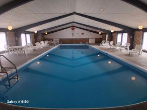 a large swimming pool in a building with chairs at St Croix Suites - St Croix Falls in Saint Croix Falls