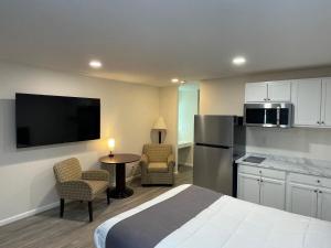 a hotel room with a bed and a refrigerator and a table at St Croix Suites - St Croix Falls in Saint Croix Falls