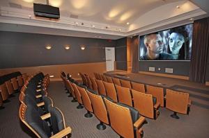 a cinema room with a large screen and chairs at Gulf-Front Paradise, Steps to Beach & Pool Access in Panama City Beach +24 photos
