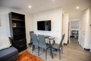 a dining room with a table and chairs and a couch at Cozy 2 Bed Flat in Town Centre in Royal Tunbridge Wells