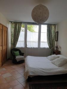 a bedroom with a bed and a chair and a window at Studio, chambre d'hôtes dans mas provençal in Sauzet +5 photos