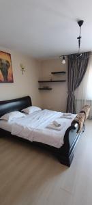 a bedroom with a large bed with white sheets at Cazare Garden Bragadiru Clinceni Domnești in Ordoreanu
