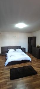 a bedroom with a large bed with white sheets and pillows at Cazare Garden Bragadiru Clinceni Domnești in Ordoreanu +3 photos