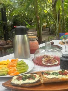 a table with plates of food and a tea kettle at REFUGIO do SAGRADO MORERE Tropical Lodge - A CASA das BRUXAS in Moreré +36 photos