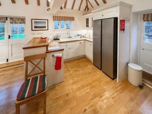 a kitchen with white cabinets and a stainless steel refrigerator at Leacon Hall Lodge in Orlestone