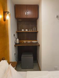 a room with a bed and a shelf with dishes at Elite Nest in Ahangama