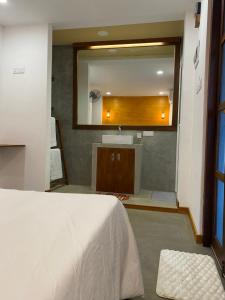 a bathroom with a bed and a sink and a mirror at Elite Nest in Ahangama +4 photos
