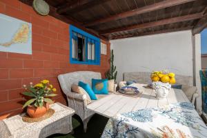 a patio with a table and chairs and a brick wall at Cabin in front of idyllic majanicho beach in Majanicho