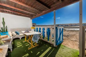 a patio with a table and chairs on a balcony at Cabin in front of idyllic majanicho beach in Majanicho