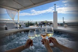 two people holding glasses of wine in a hot tub at Luxury suite with Jacuzzi in Epanomi